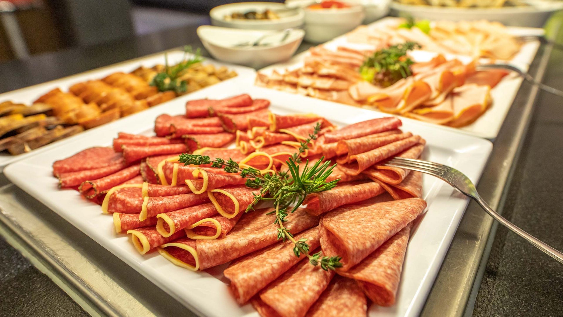 Assorted cold cuts and sausages with herbs on a buffet platter