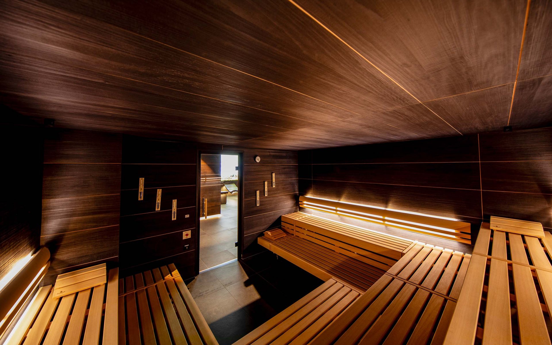 Innenansicht einer modernen Holzsauna mit Sitzbänken und indirekter Beleuchtung