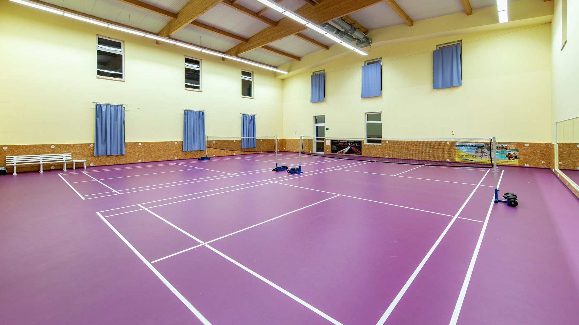 Empty badminton court with purple floor in an indoor sports hall