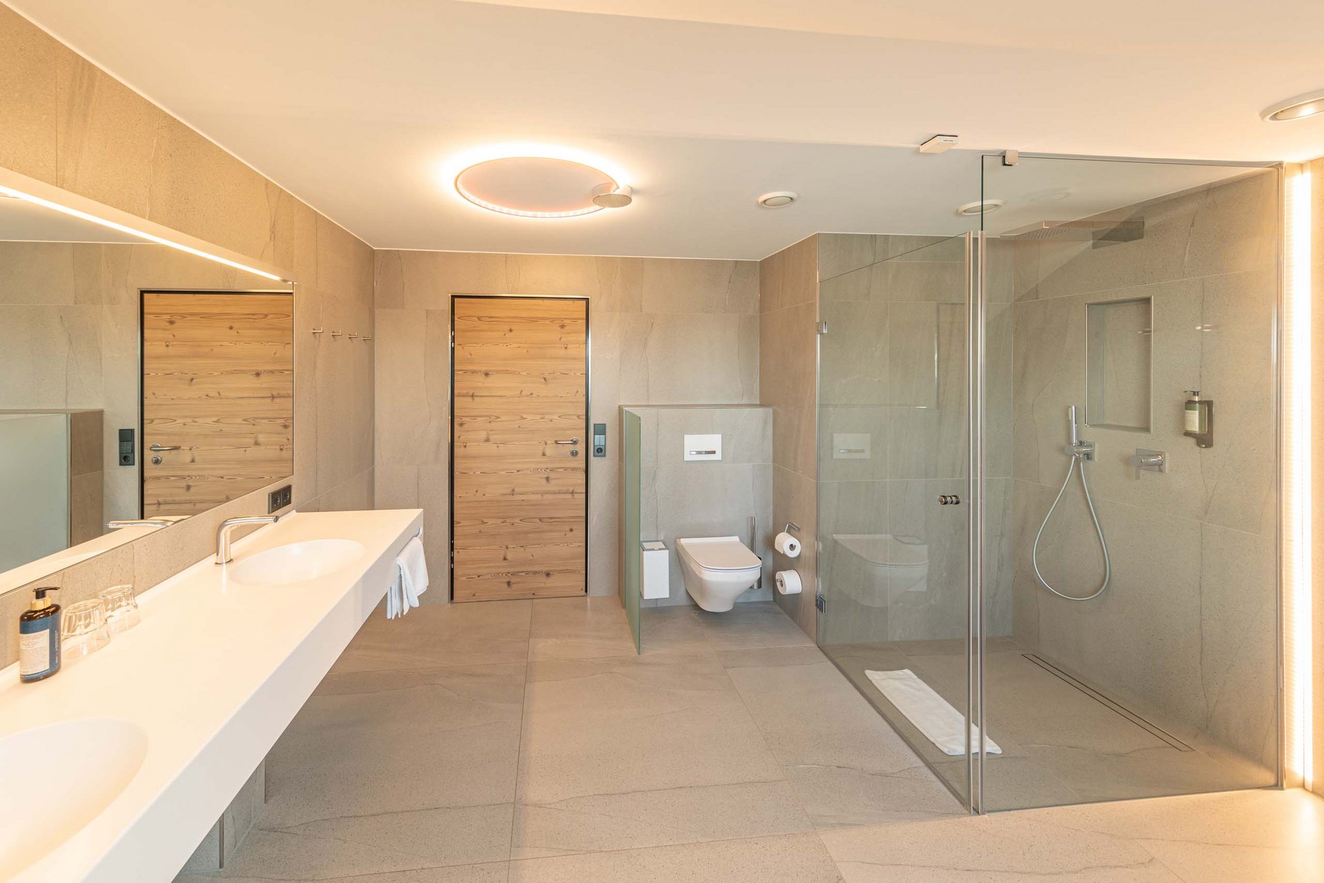 Modernes Badezimmer mit Doppelwaschbecken, Dusche und WC