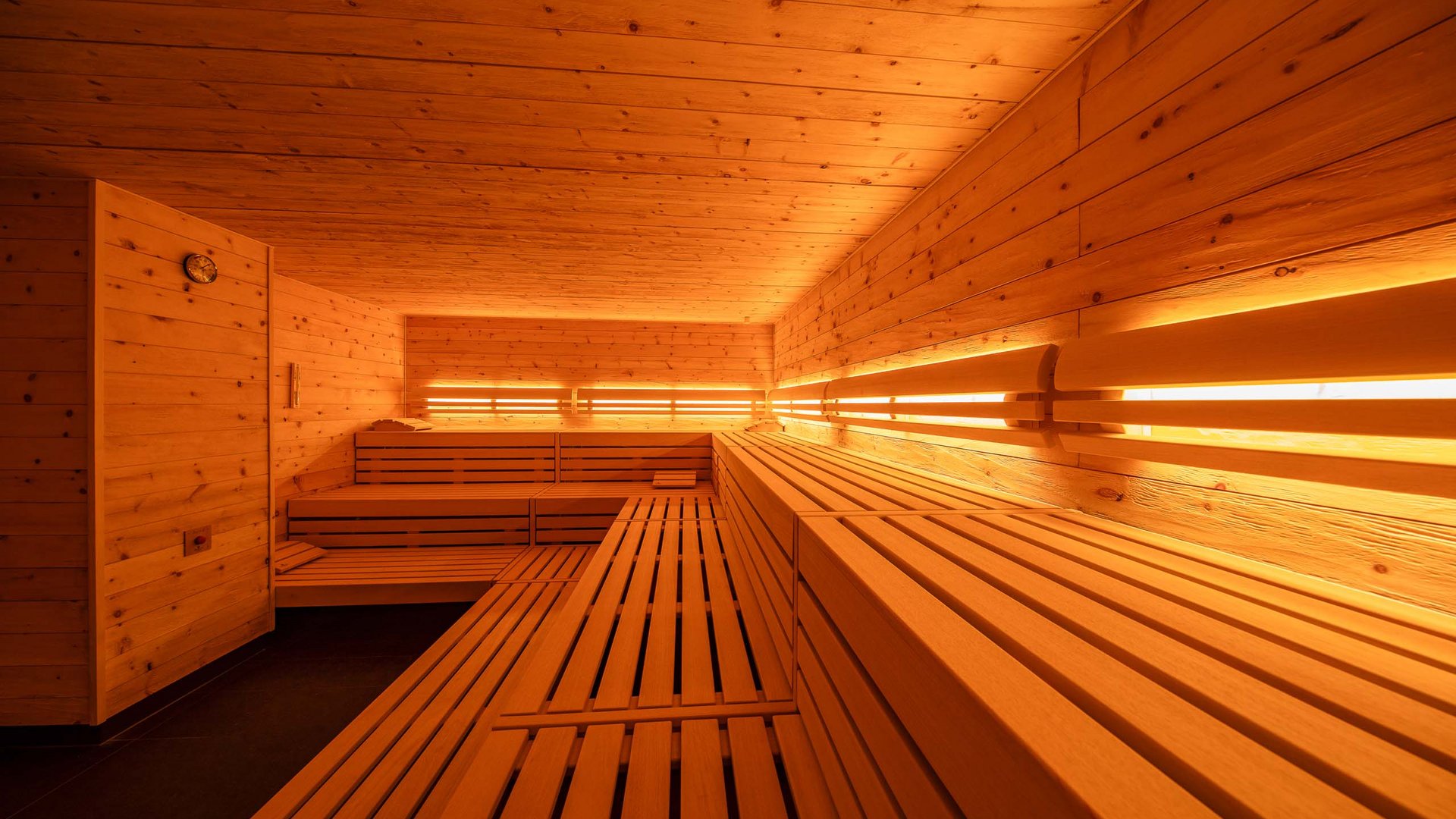 Interior of a modern wooden sauna with benches and warm lighting