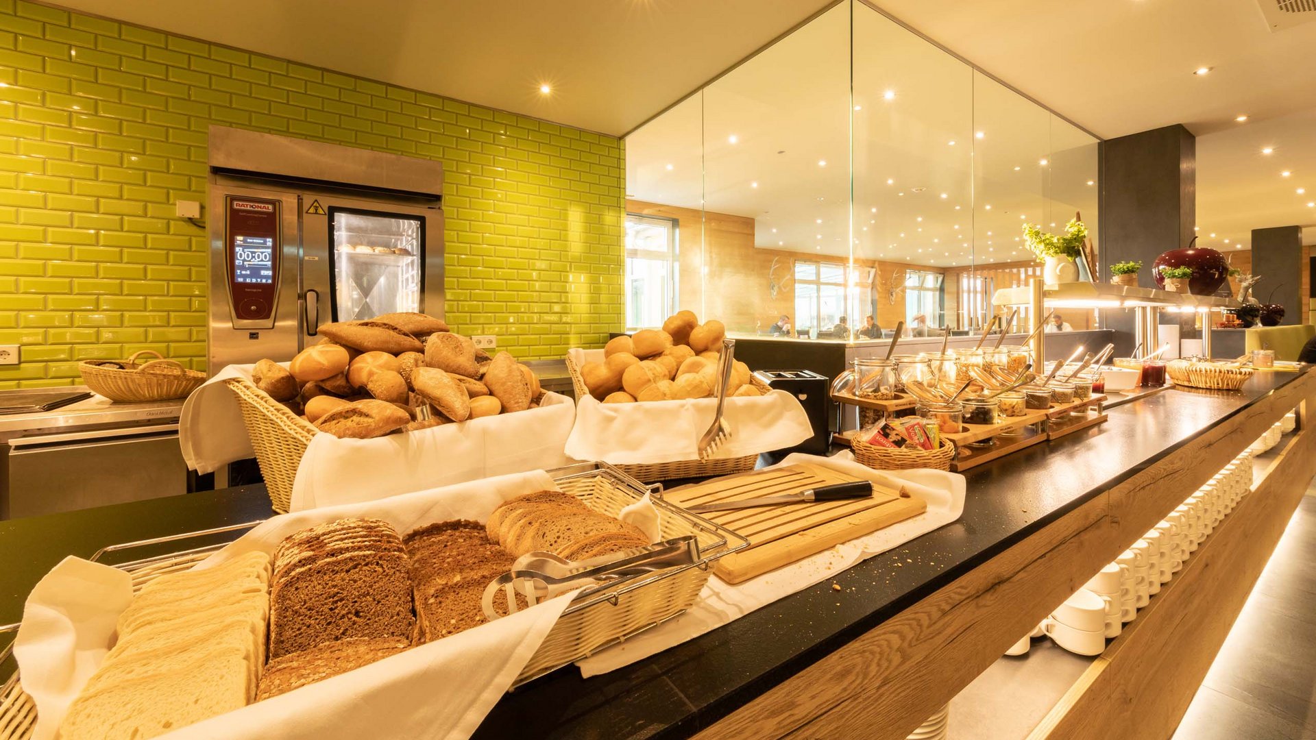 Buffet mit verschiedenen Brotsorten und Aufstrichen in einem hellen Restaurant