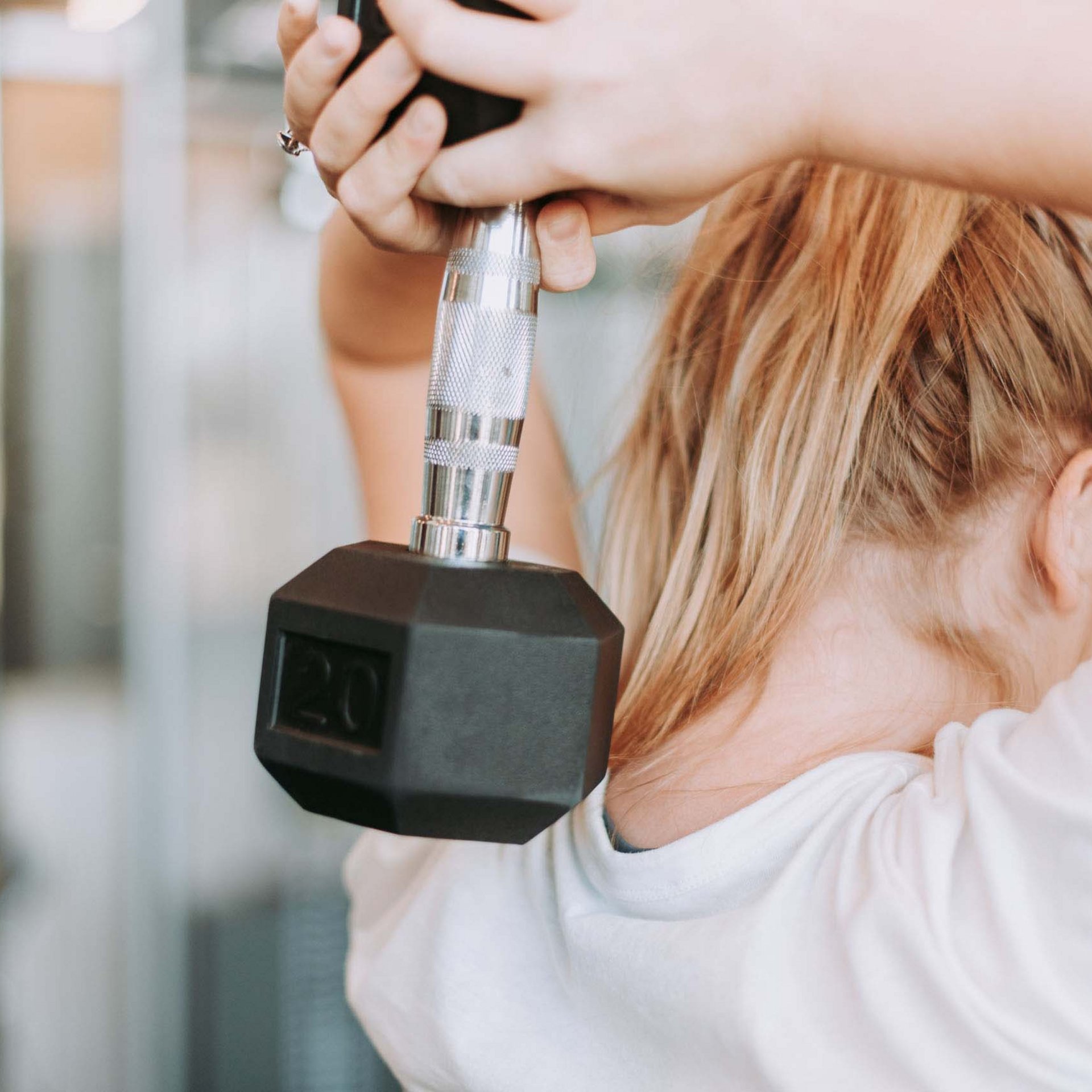 Frau trainiert mit 20-Pfund-Hantel im Fitnessstudio