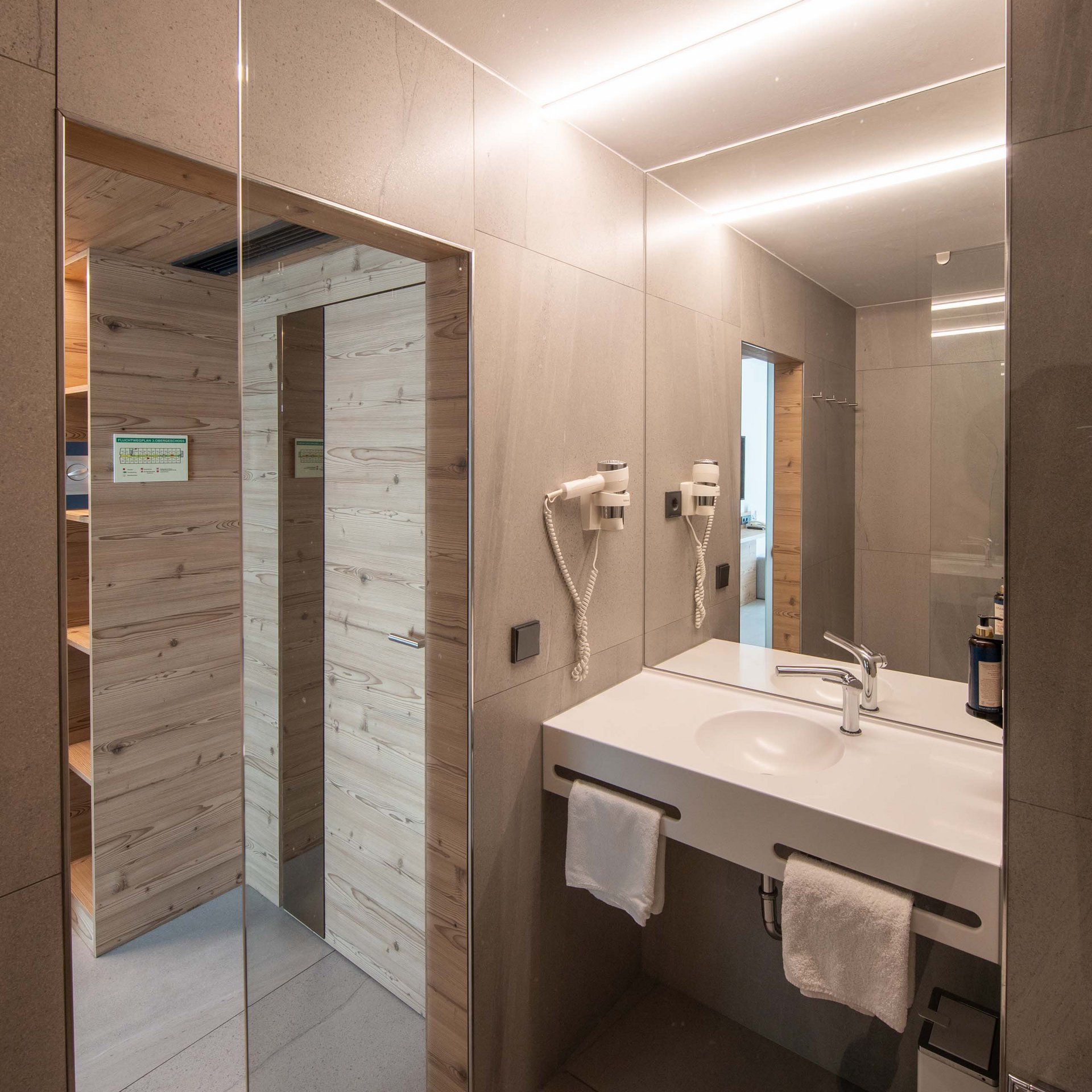 Modernes Badezimmer mit Doppelwaschbecken und Wandhaartrockner