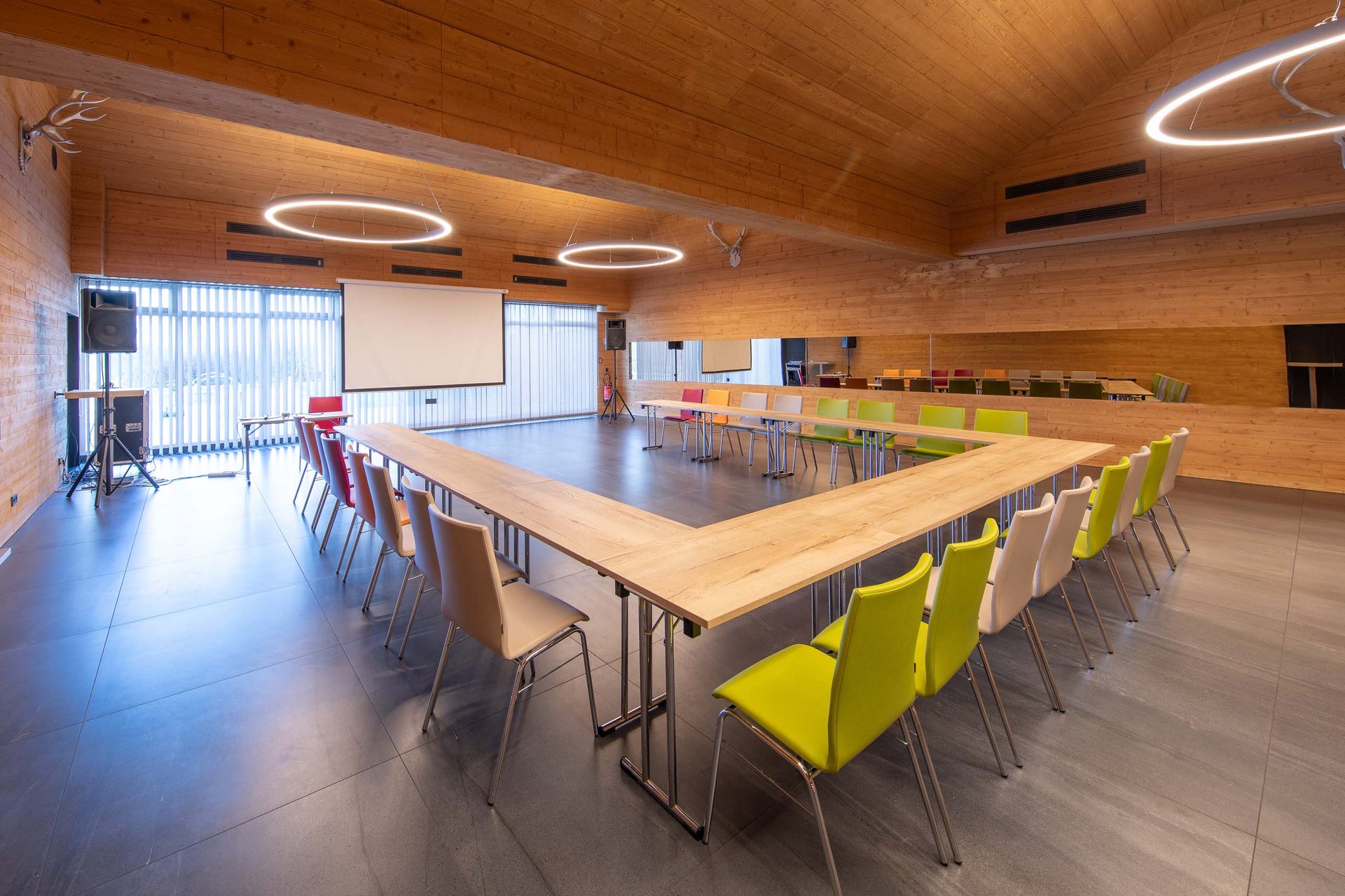 Modern conference room with U-shaped table and colorful chairs