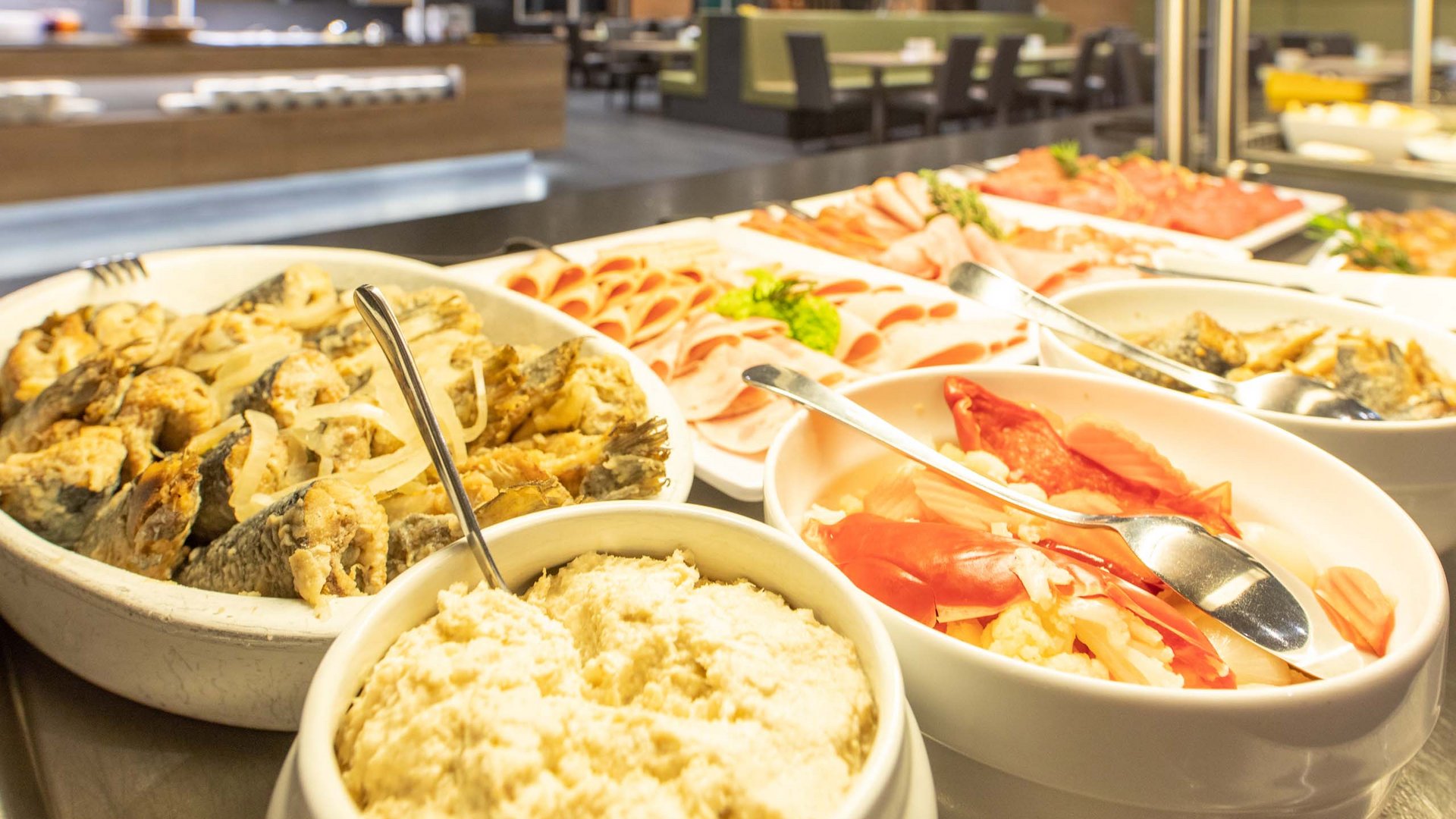 Buffet with various meat and fish dishes in white bowls