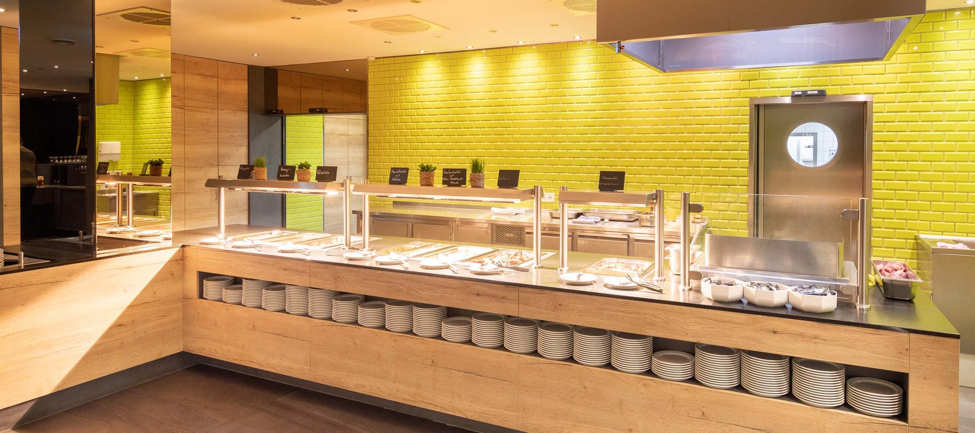 Helles Buffet mit Holzfront und gelben Kacheln im Hintergrund