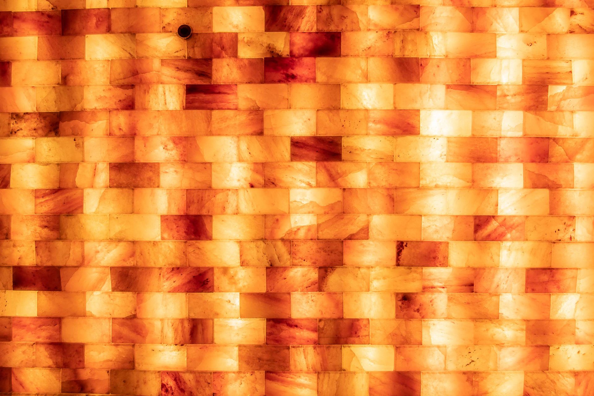 Wand aus leuchtenden, rot-orangefarbenen Steinplatten