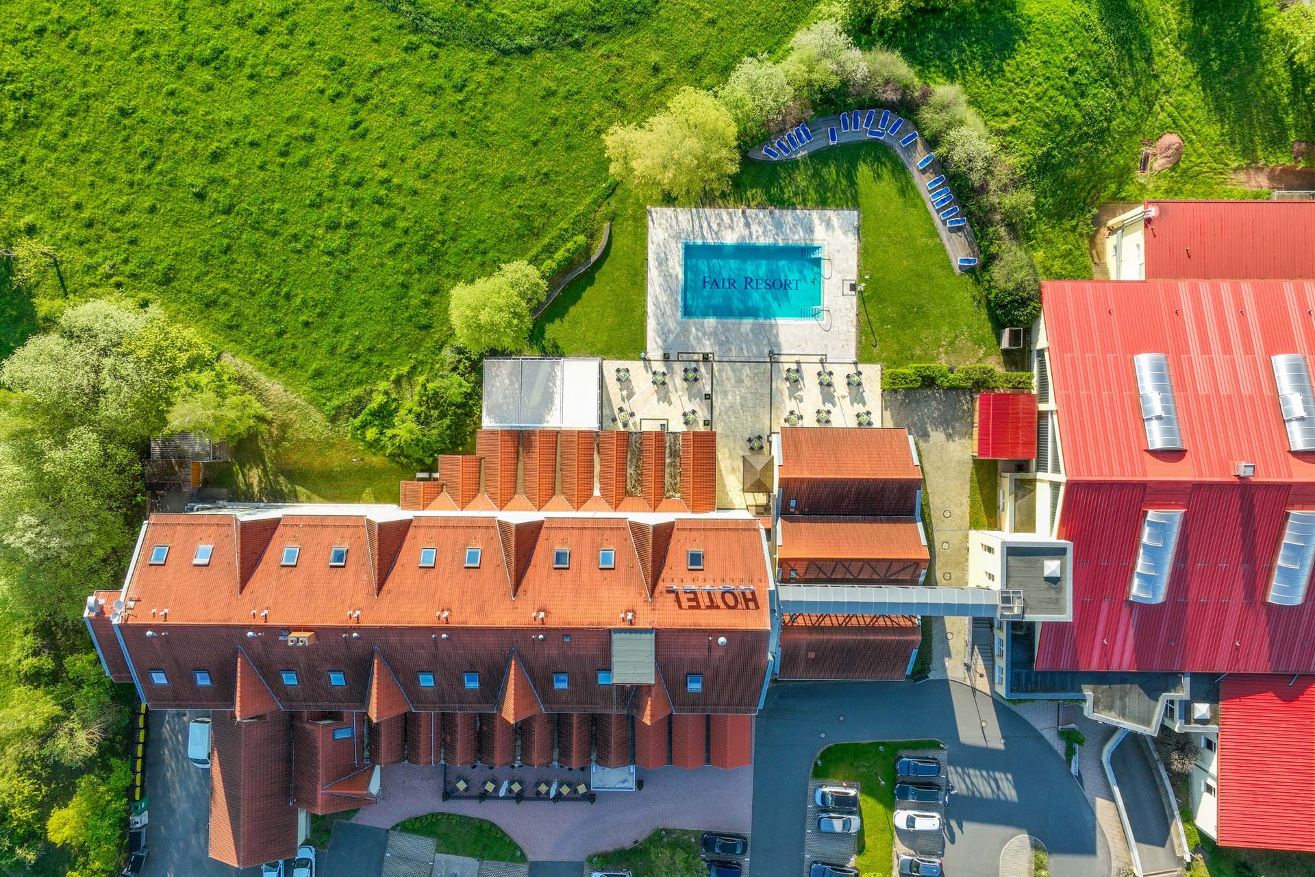 Luftaufnahme eines Hotels mit Pool und grüner Wiese
